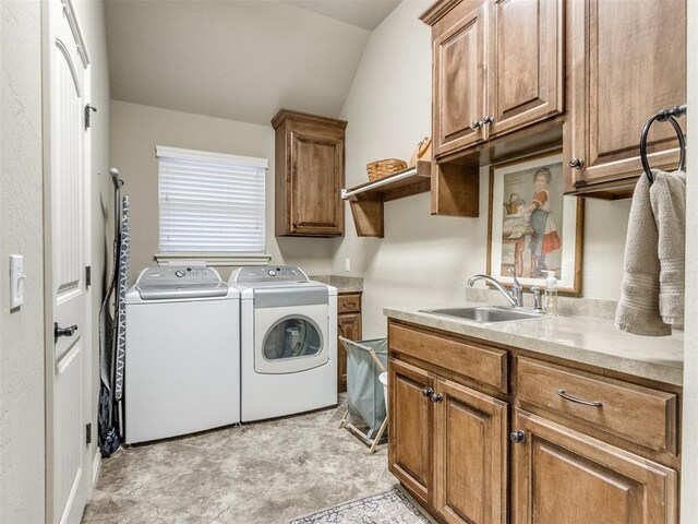 washroom with a sink, cabinet space, and separate washer and dryer