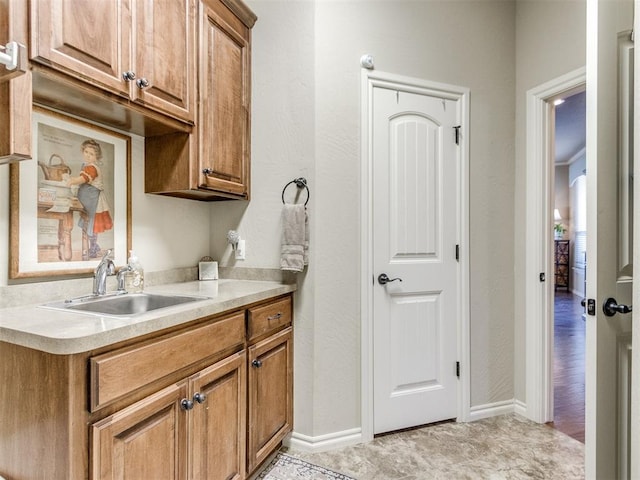 kitchen with brown cabinets, light countertops, and a sink