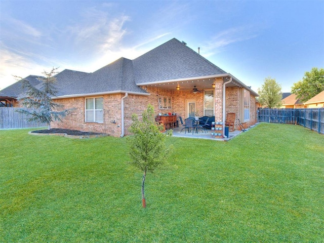back of house with a fenced backyard, a patio area, ceiling fan, and a yard