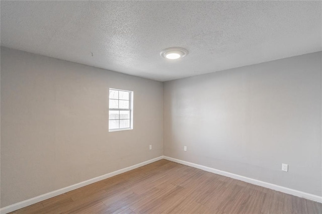 spare room with wood-type flooring and a textured ceiling