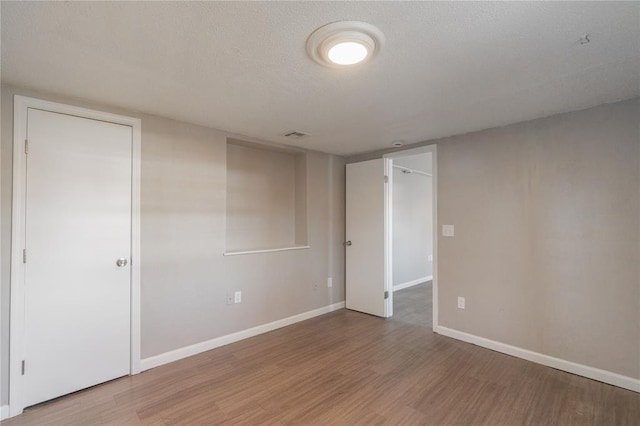 unfurnished room featuring hardwood / wood-style floors and a textured ceiling