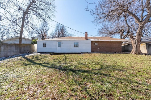 rear view of house featuring a lawn