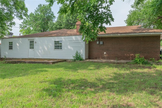 3000 N Viewpoint Dr, Midwest City, OK 73110 - rear view of property with a lawn, a chimney, and brick siding