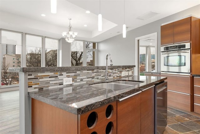 5900 Mosteller Dr Unit St32, Oklahoma City, OK 73112 - kitchen with pendant lighting, appliances with stainless steel finishes, a sink, an island with sink, and modern cabinets
