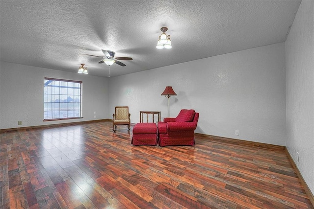 living area featuring a textured ceiling, dark wood-type flooring, and ceiling fan