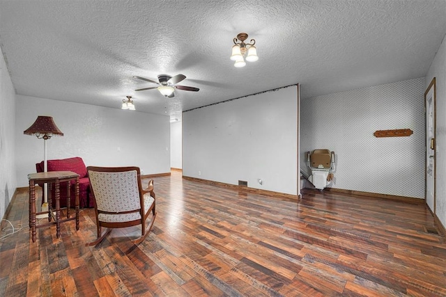 living area featuring ceiling fan, a textured ceiling, and dark hardwood / wood-style flooring