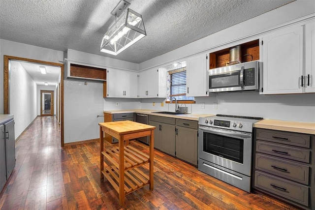 kitchen with dark wood-type flooring, sink, white cabinetry, appliances with stainless steel finishes, and gray cabinets