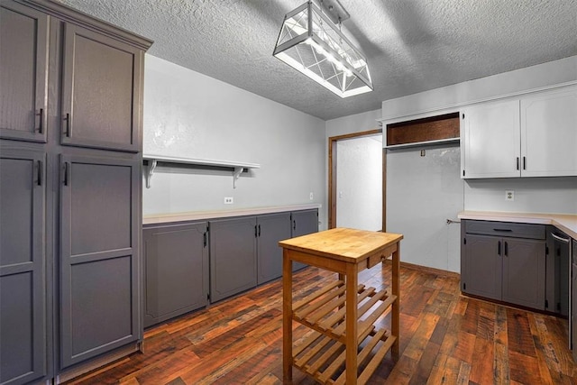 kitchen featuring gray cabinetry, white cabinetry, dark wood-type flooring, and a textured ceiling