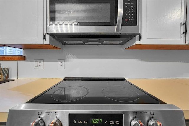 room details with appliances with stainless steel finishes and white cabinets