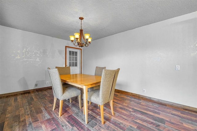 dining room with an inviting chandelier, dark hardwood / wood-style flooring, and a textured ceiling