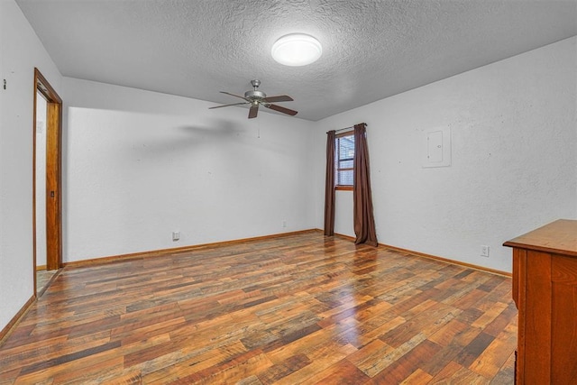 unfurnished room featuring ceiling fan, dark hardwood / wood-style flooring, and a textured ceiling