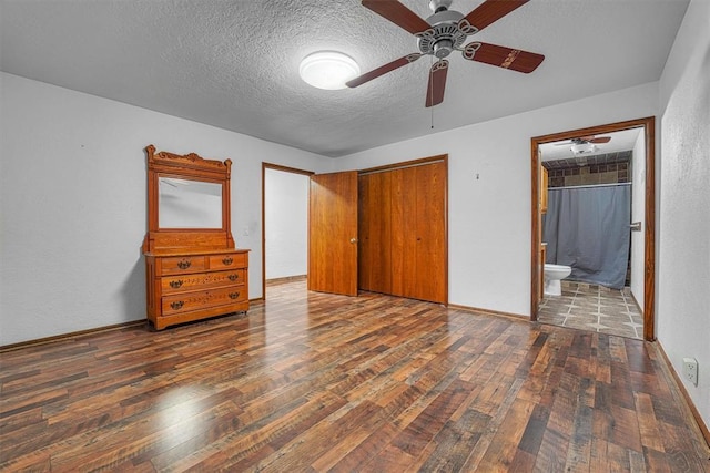 unfurnished bedroom with dark wood-type flooring, ensuite bath, a closet, and a textured ceiling