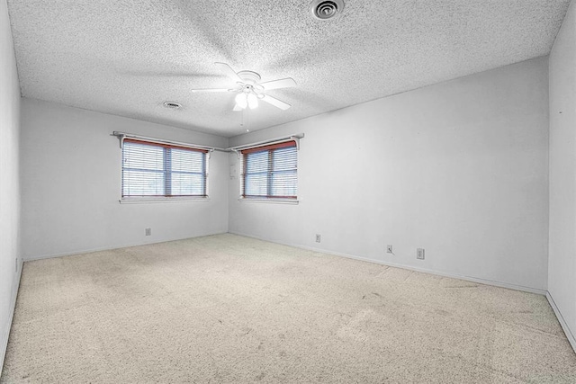 carpeted spare room with ceiling fan and a textured ceiling