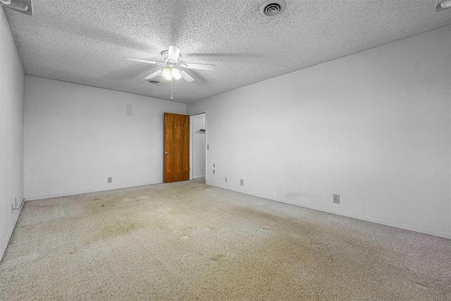 unfurnished room with a textured ceiling, ceiling fan, and carpet