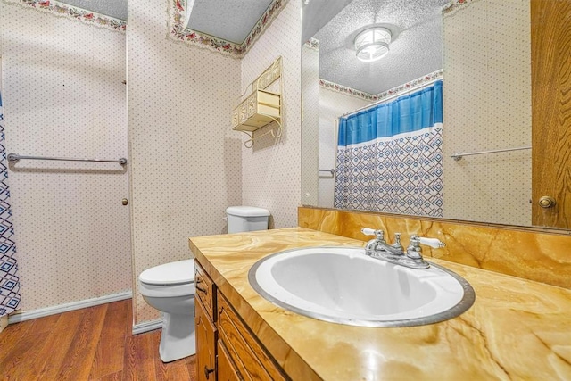 bathroom featuring hardwood / wood-style flooring, vanity, a textured ceiling, and toilet