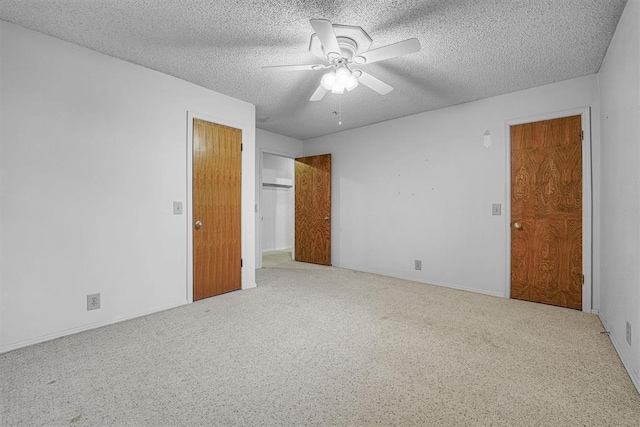 carpeted empty room with ceiling fan and a textured ceiling