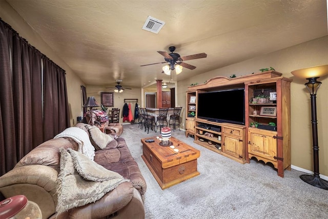 carpeted living room with a textured ceiling and ceiling fan