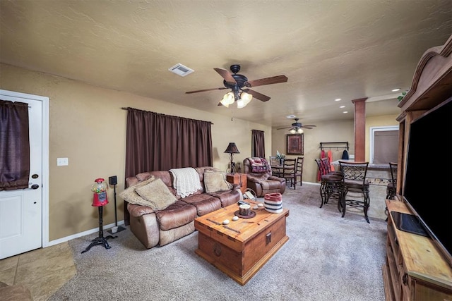 living room with ornate columns, a textured ceiling, and ceiling fan