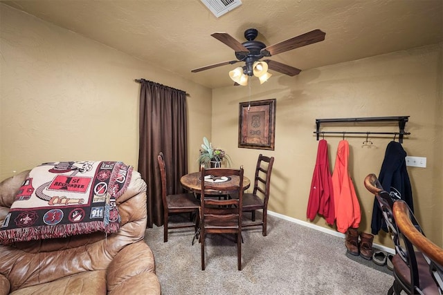 carpeted dining space with a textured ceiling and ceiling fan