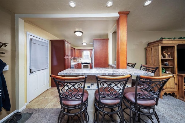 kitchen with light carpet, a kitchen breakfast bar, and kitchen peninsula