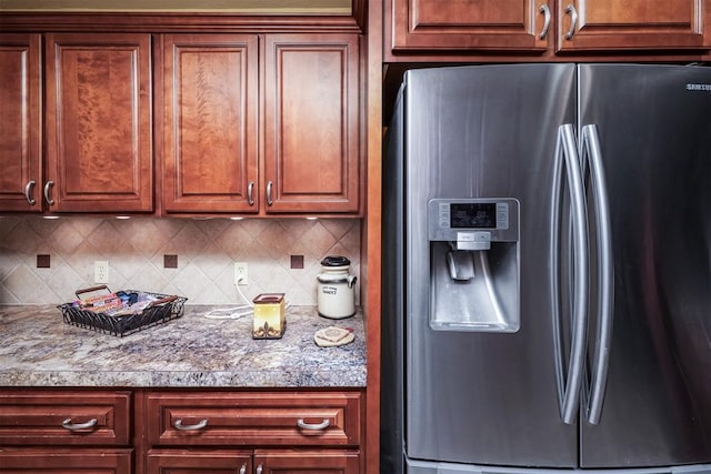 kitchen with stainless steel fridge with ice dispenser and backsplash