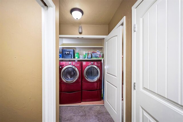 clothes washing area with washing machine and dryer and carpet flooring