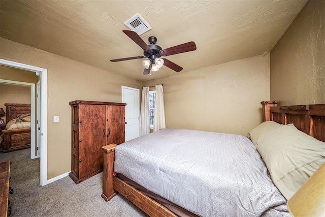 carpeted bedroom with ceiling fan and a textured ceiling