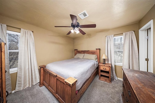 carpeted bedroom featuring ceiling fan and a textured ceiling