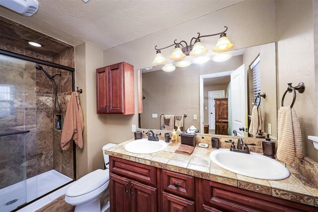 bathroom with vanity, a textured ceiling, toilet, and walk in shower