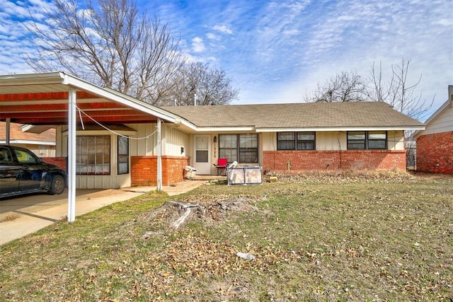 ranch-style home with a carport, brick siding, and board and batten siding