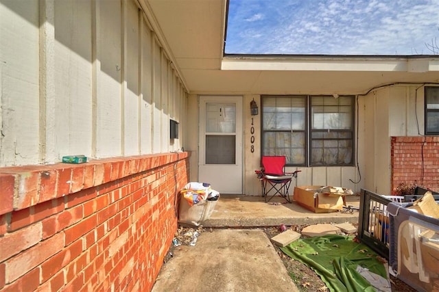 view of exterior entry with brick siding