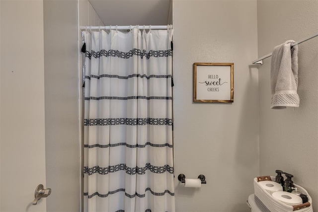 bathroom featuring curtained shower and toilet