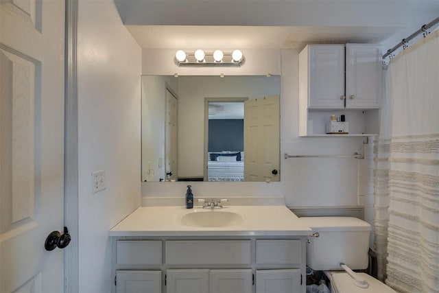 bathroom featuring vanity, walk in shower, and toilet