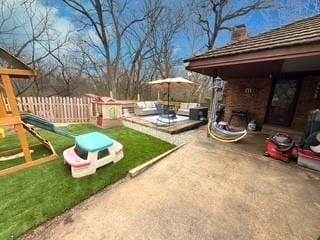 view of yard featuring a patio, a playground, outdoor lounge area, and fence