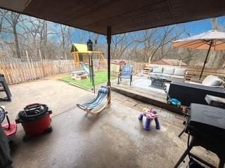 view of patio / terrace featuring a playground and fence