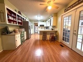 kitchen with a peninsula, light countertops, a ceiling fan, and wood finished floors
