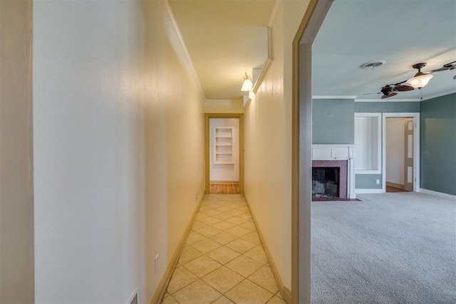 corridor with light tile patterned floors, light carpet, visible vents, baseboards, and ornamental molding