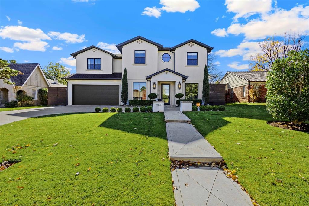 view of front of house featuring a garage and a front lawn