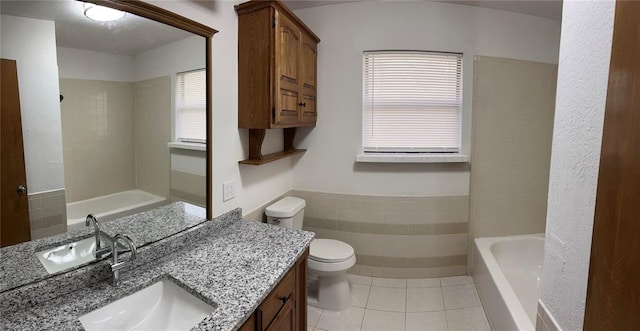 bathroom featuring tile patterned flooring, tile walls, vanity, a tub to relax in, and toilet