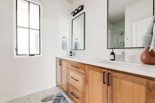 full bath featuring marble finish floor, a sink, baseboards, and double vanity