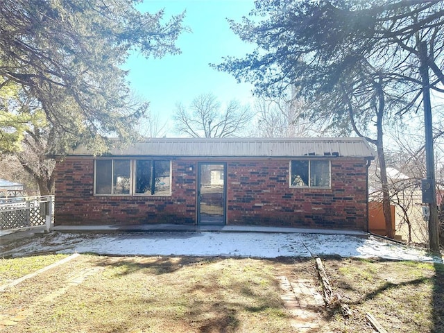 ranch-style house with a patio area, brick siding, and fence