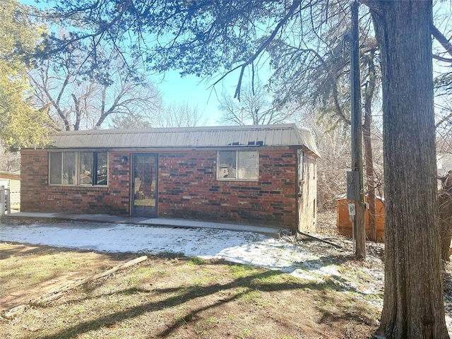 exterior space with brick siding and a lawn