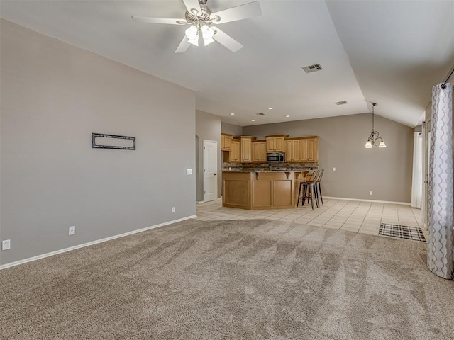 unfurnished living room with ceiling fan with notable chandelier, light colored carpet, and lofted ceiling