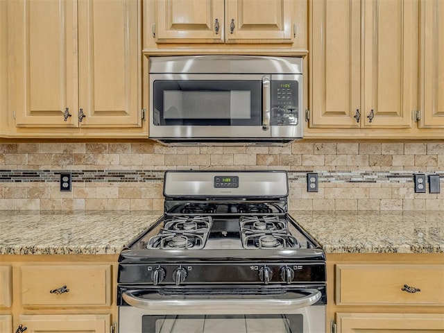 kitchen featuring light stone countertops, appliances with stainless steel finishes, and light brown cabinetry