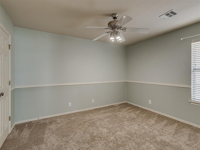 spare room with ceiling fan, plenty of natural light, and carpet