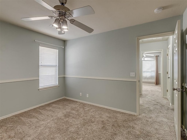 carpeted spare room with ceiling fan