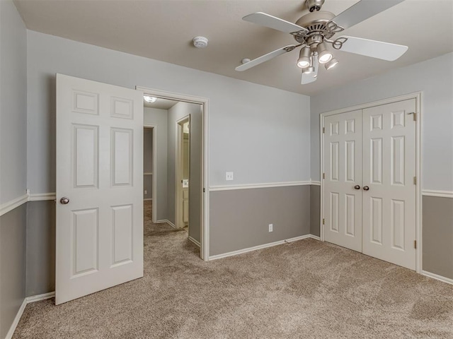 unfurnished bedroom featuring ceiling fan, a closet, and light carpet