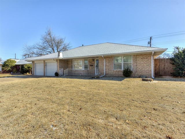 single story home featuring a garage, covered porch, and a front lawn