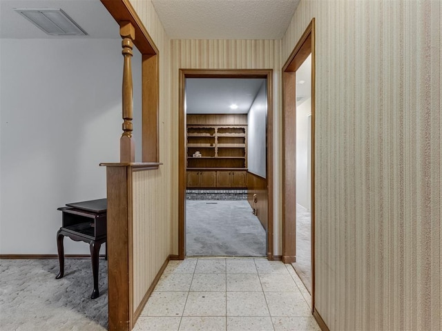 7000 N Libby Ave, Oklahoma City, OK 73132 - corridor featuring light carpet, a textured ceiling, and built in shelves