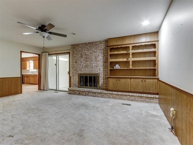 7000 N Libby Ave, Oklahoma City, OK 73132 - unfurnished living room with light carpet, a brick fireplace, sink, and wood walls